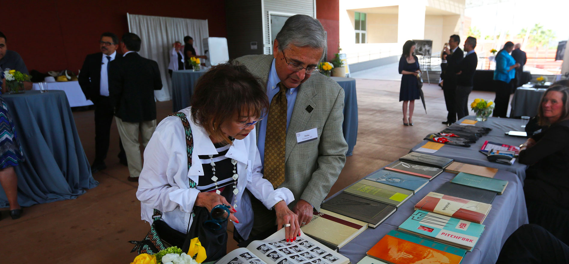 Alumni look through old L.A. State University year books Class of 1966 reunion.