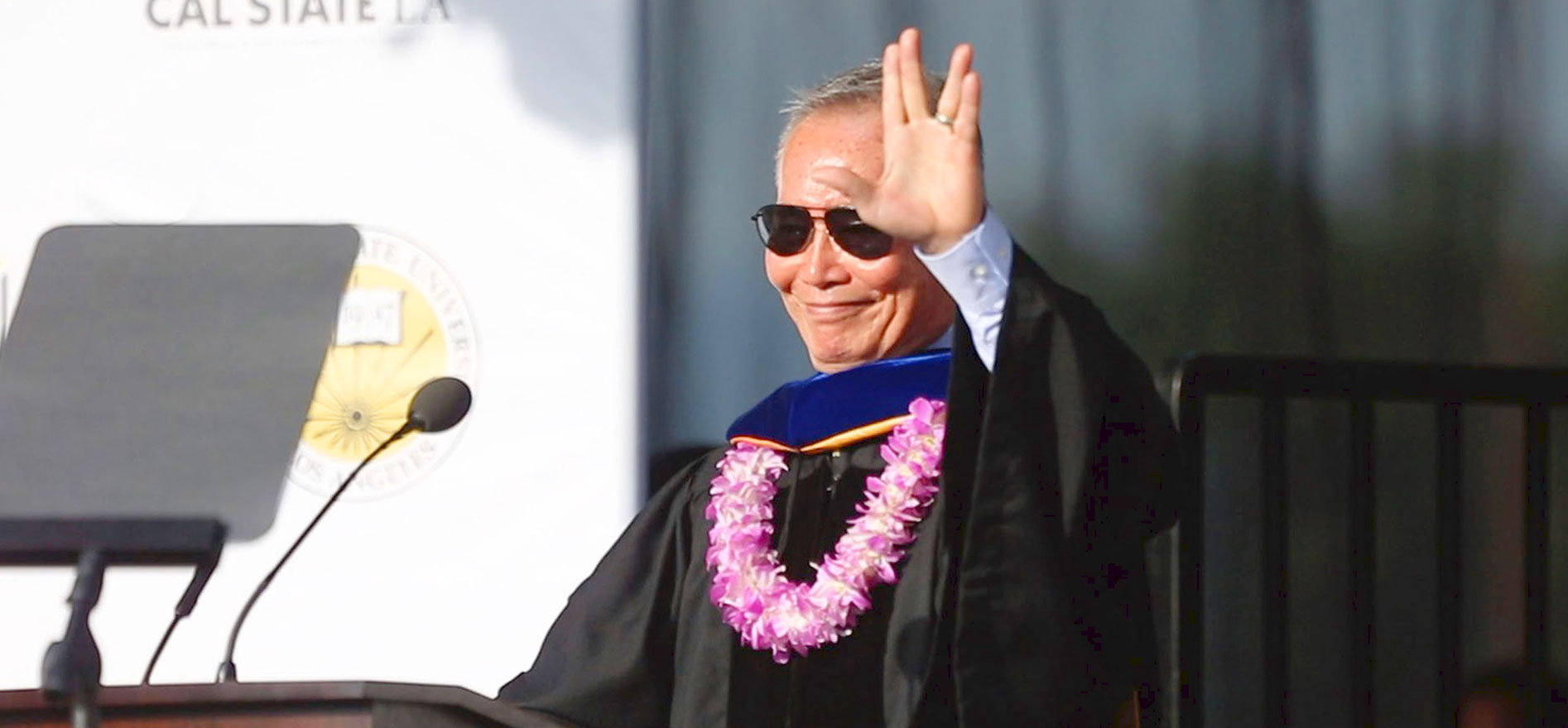 George Tekei speaks from a podium at a Cal State LA Commencement ceromeny.