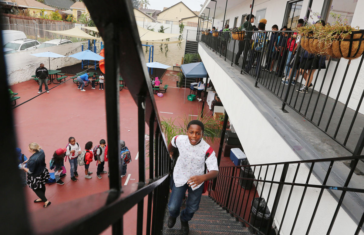 Students getting to their classrooms at Crete Academy. Young student climbing up stairs to get to class at Crete Academy.