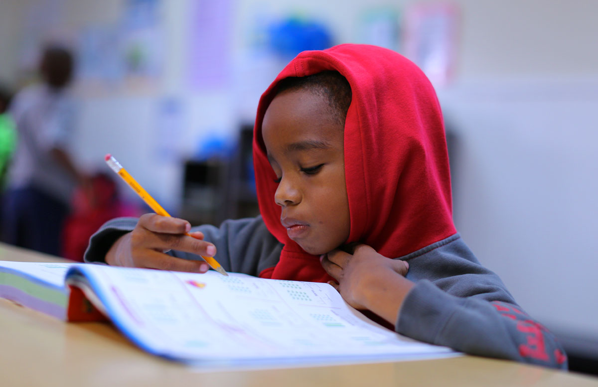 Crete Academy student reading a textbook. Student reading a textbook at Crete Academy.