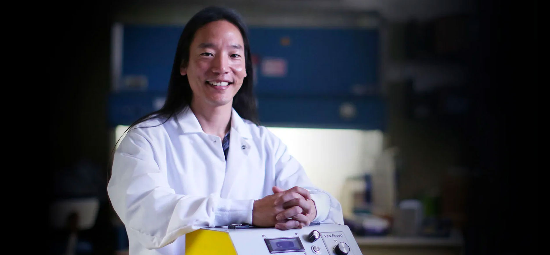 Alumnus John Chi stands next to his invention, the Synova Device.