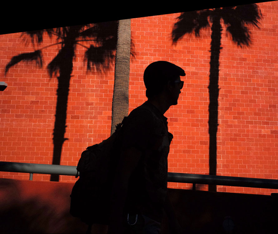 Student walking past the red brick bookstore. Student walking past the red brick bookstore.