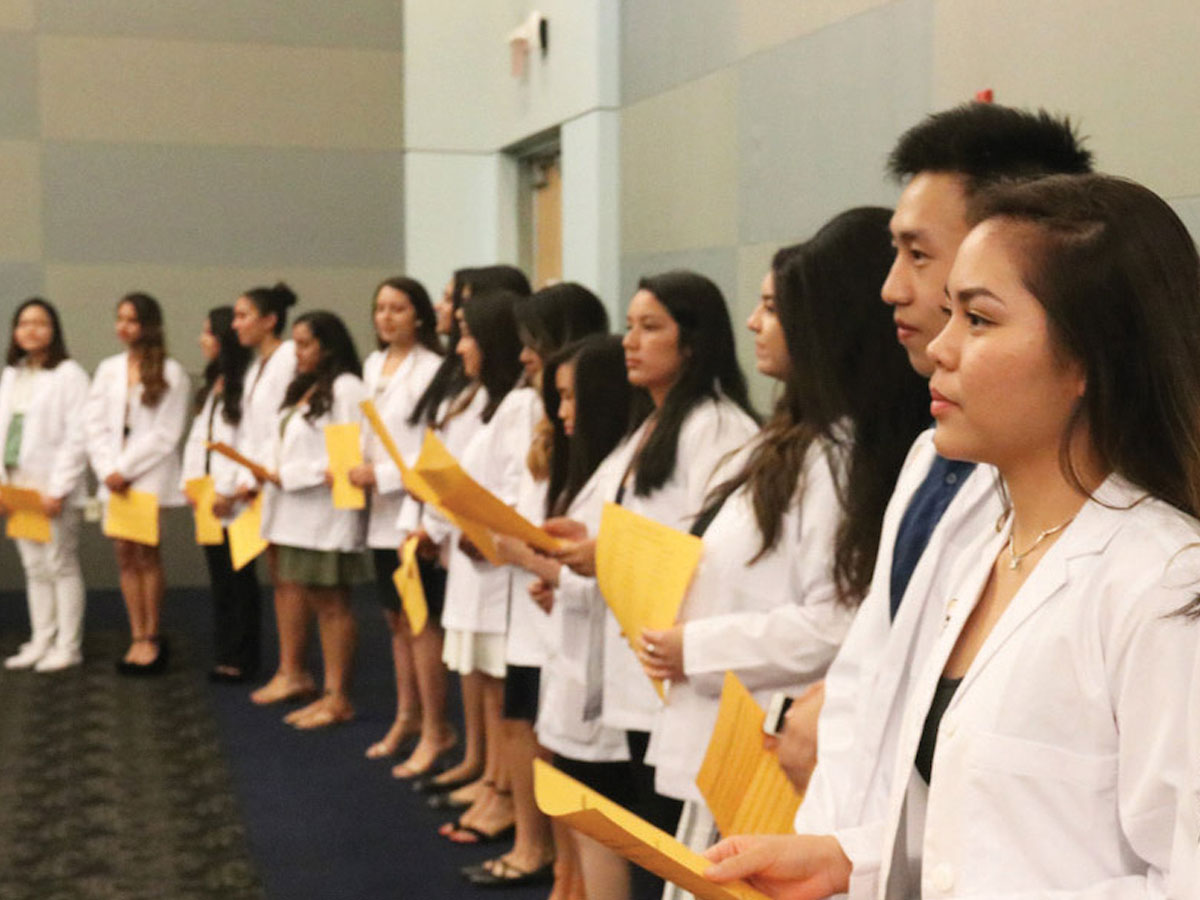 Nursing students stand together during their white coat ceremony Nursing students stand together during their white coat ceremony