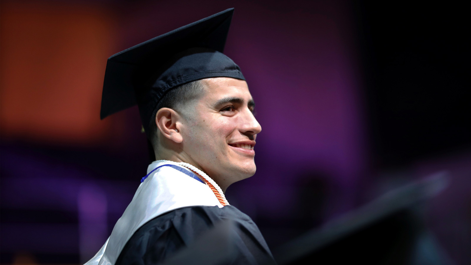 Rojas in a graduation cap, smiling brightly. Rojas in a graduation cap, smiling brightly.
