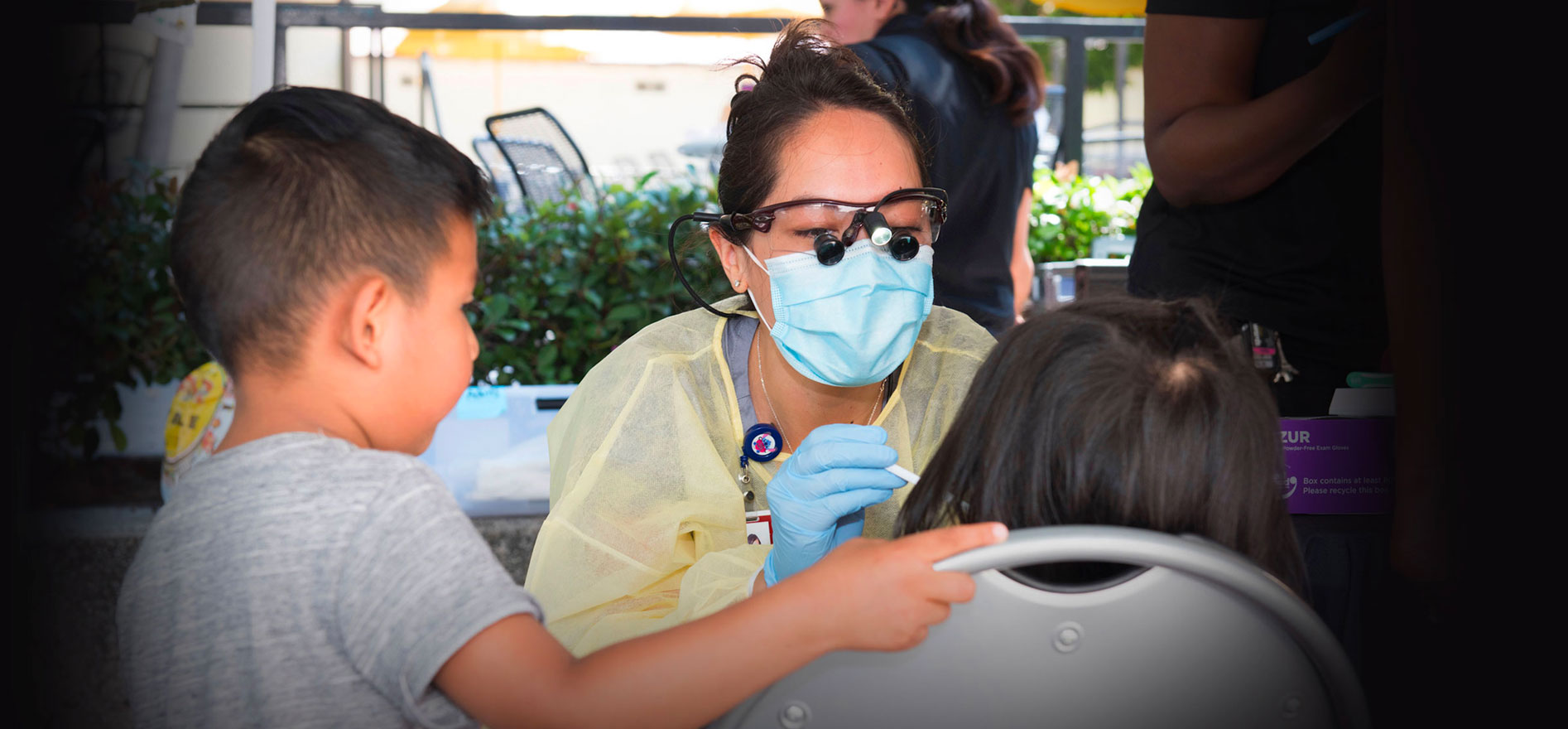 A child seated being provided dental care as part of the Cal State LA ECHO- ocal Dental Pilot Project program.