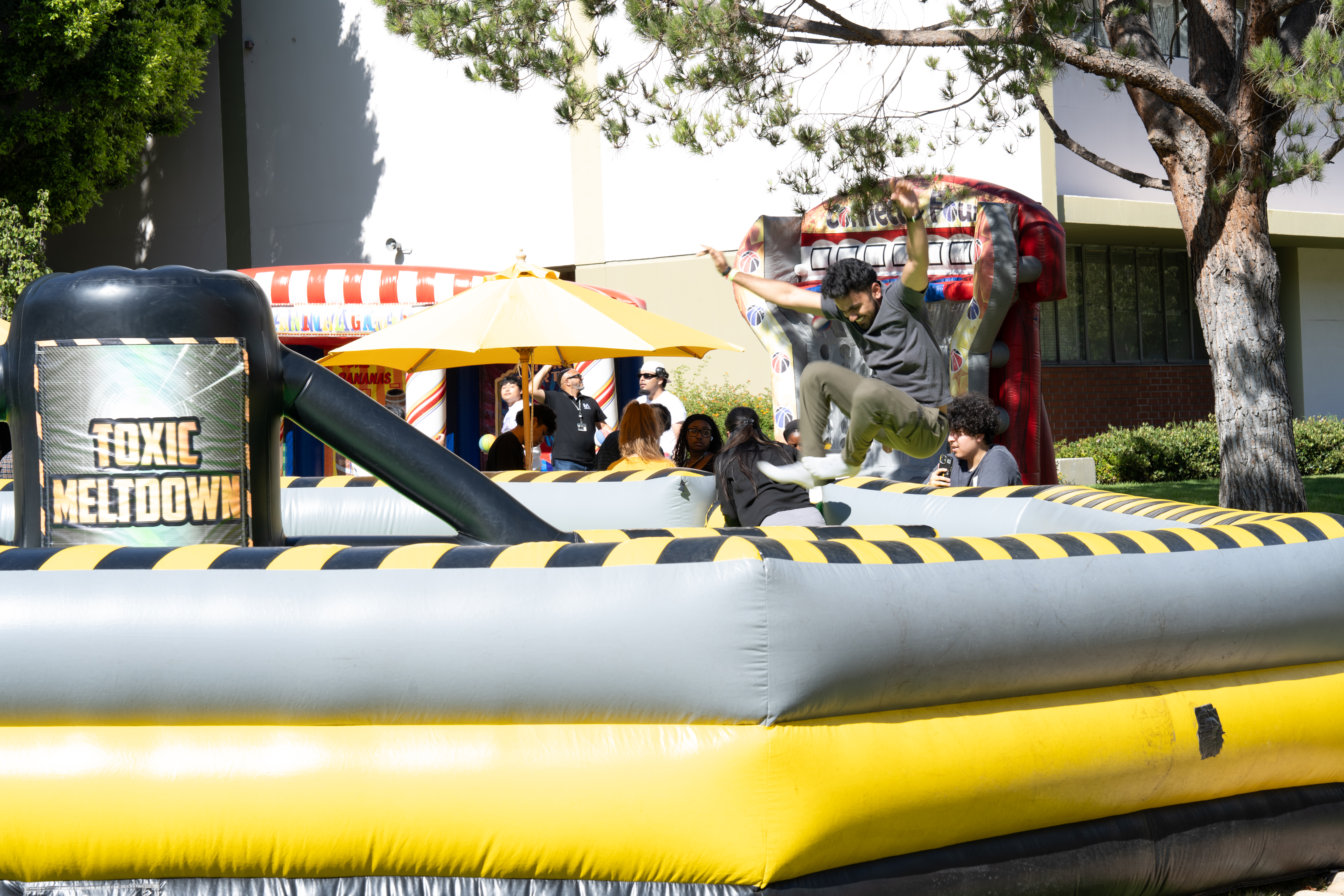 Students enjoy a “Toxic Meltdown” inflatable game during Cal State LA Campus Day 2025, celebrating with outdoor activities and games on campus.