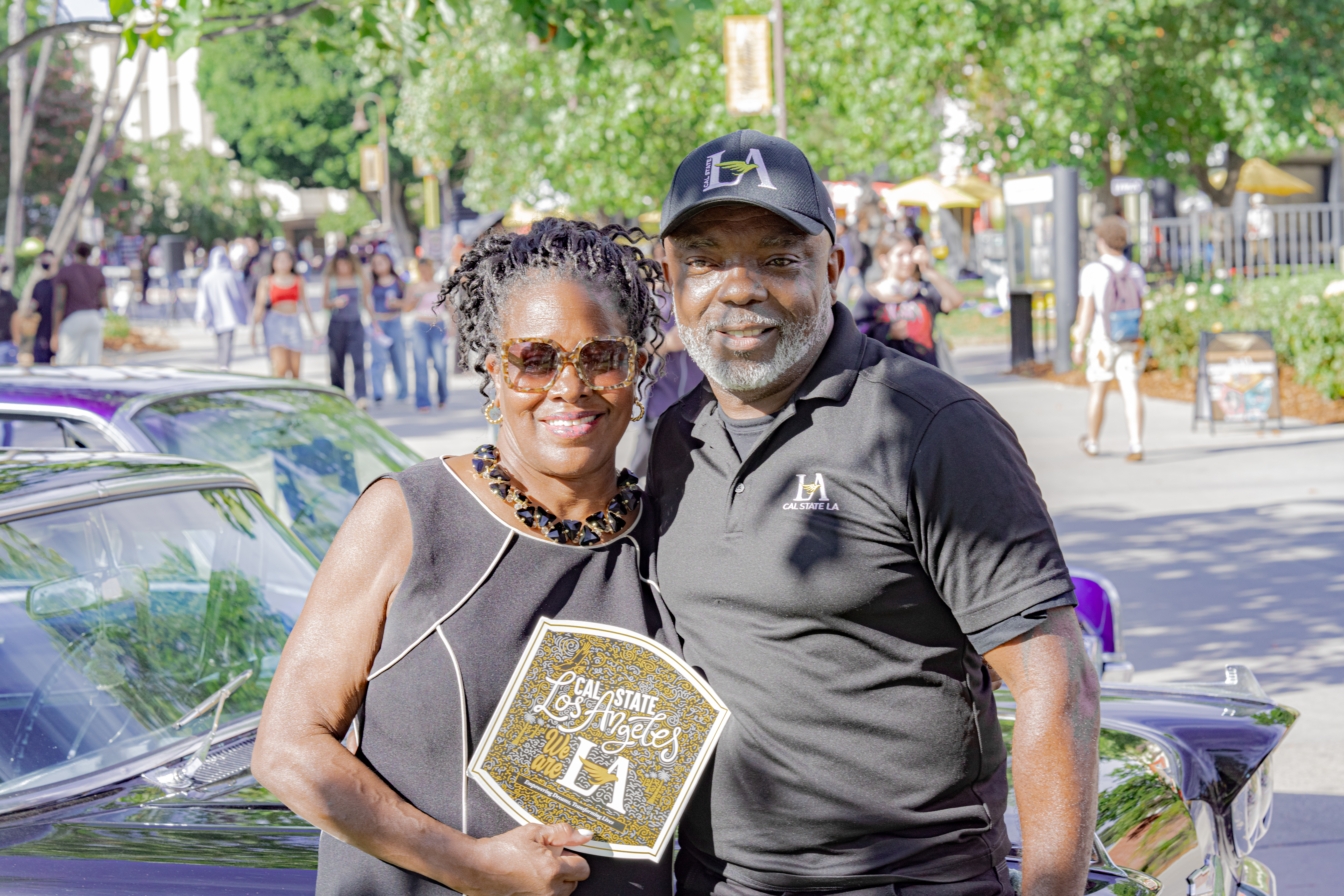 Cal State LA President Berenecea Johnson Eanes and the Cal State LA Police Chief smile together beside a classic car during Campus Day 2025 festivities.