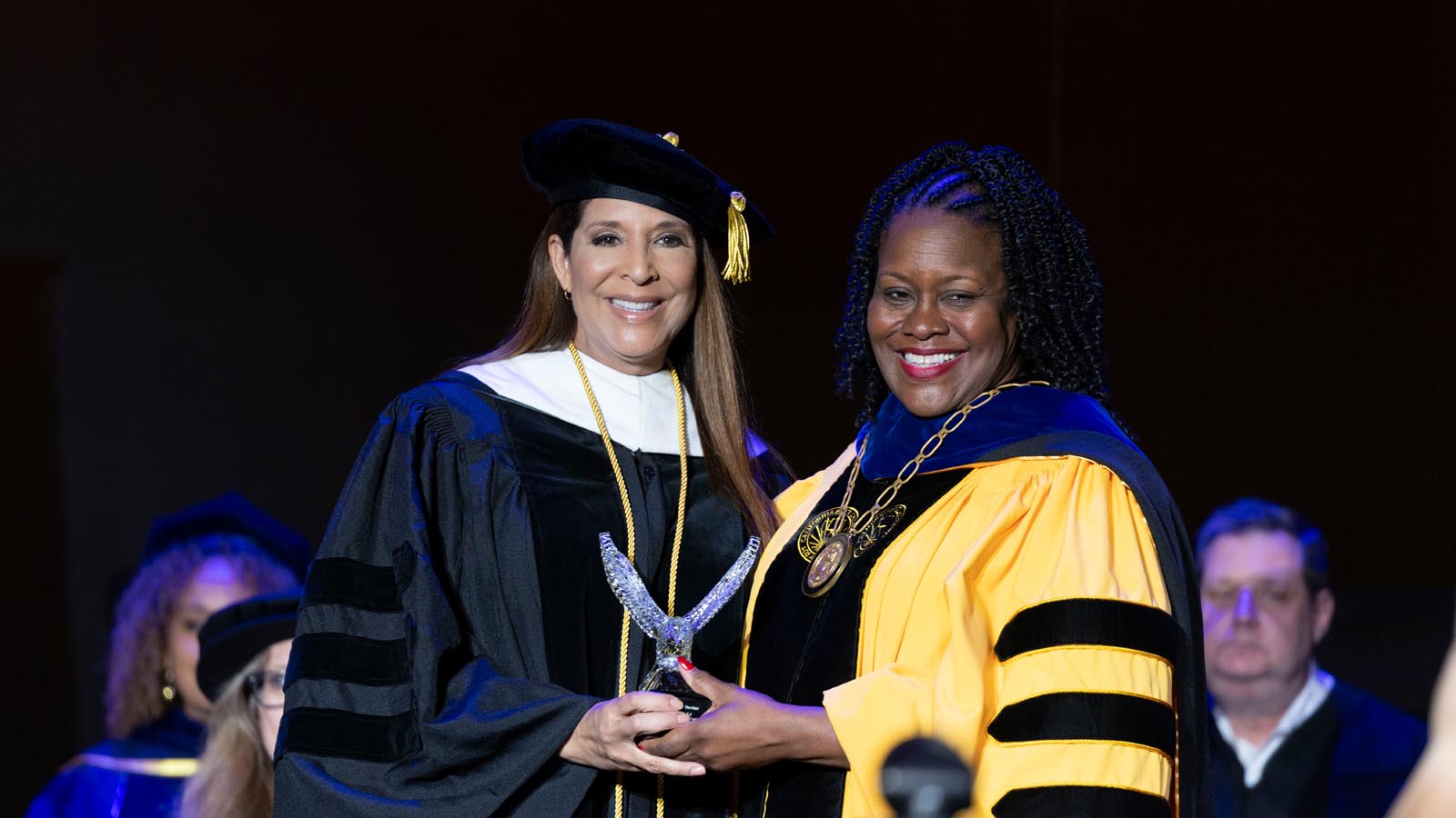 Cal State LA President Berenecea Johnson Eanes presents an Eagle Award to an honoree during the 2025 Commencement ceremony at the Shrine Auditorium.