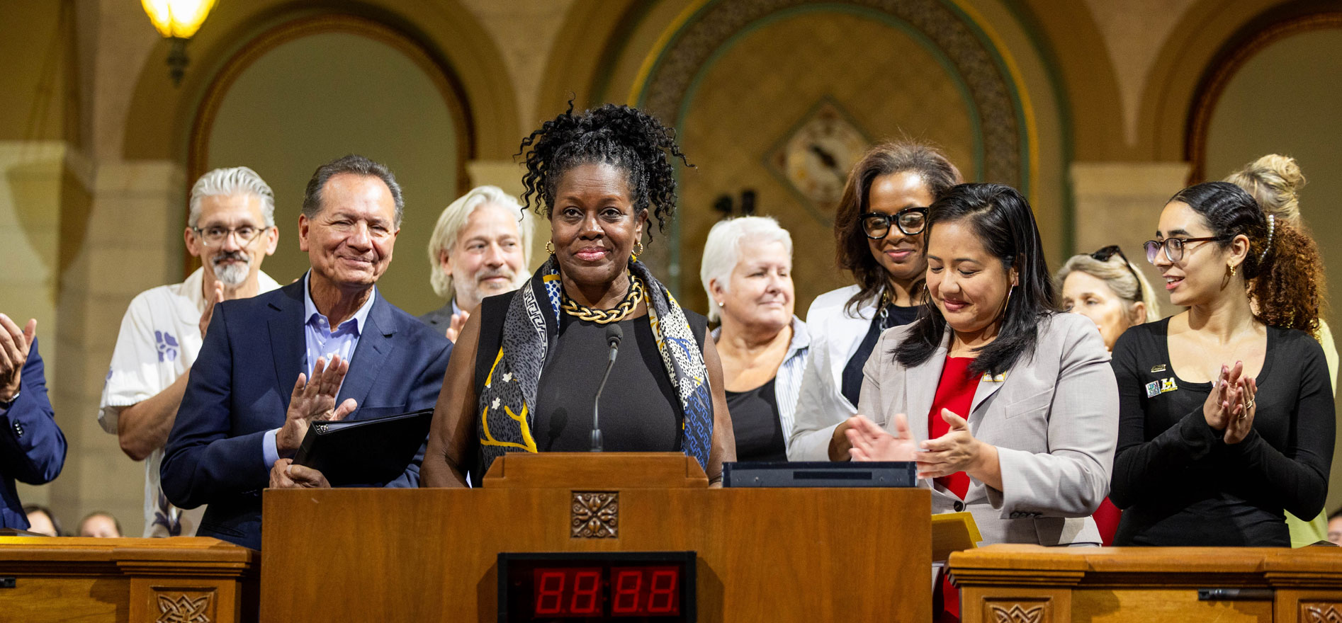 Cal State LA President Berenecea Johnson Eanes speaks at the podium during Cal State LA Day at Los Angeles City Hall, surrounded by University leaders, students, and city officials.