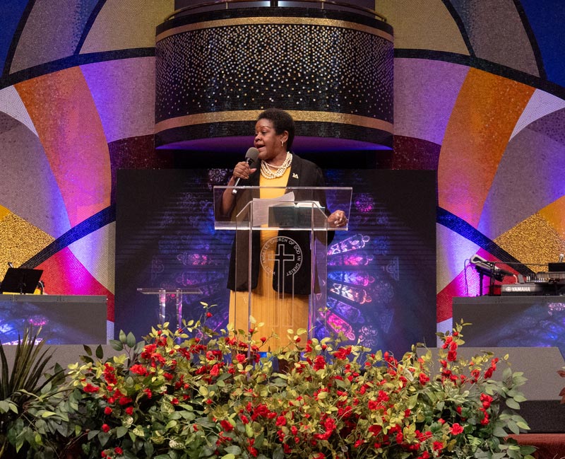 A person speaks through a microphone from behind a podium.