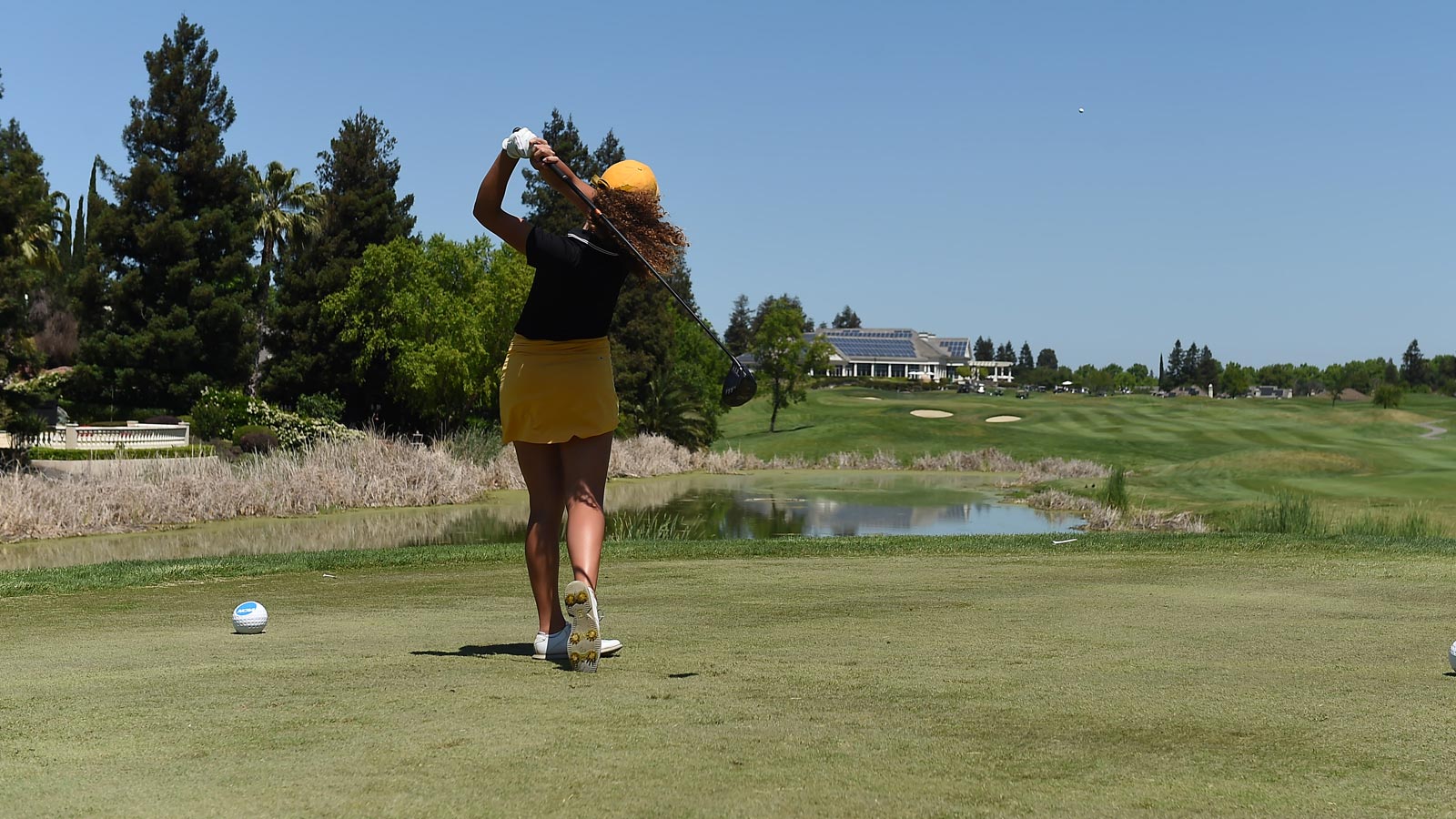 Cal State LA golfer Morgan Sjoerdsma tees off on a sunny course, swinging toward the fairway during a collegiate tournament.