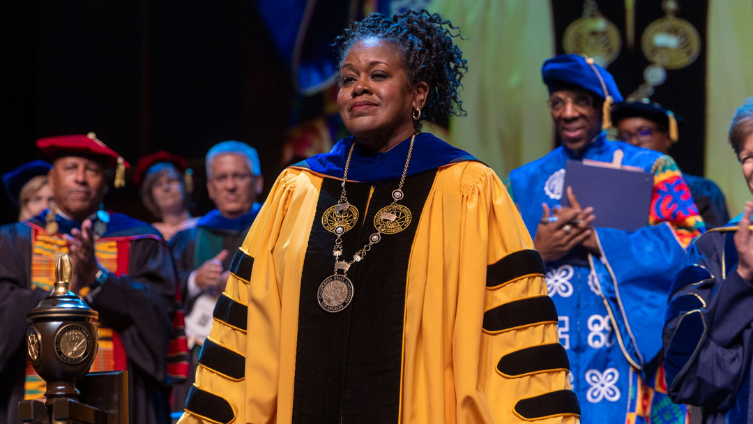 President Berenecea Johnson Eanes in a gold and black gown.